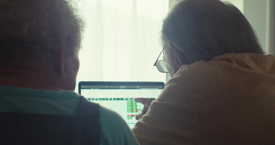 A man and woman talk while pointing at information on the computer