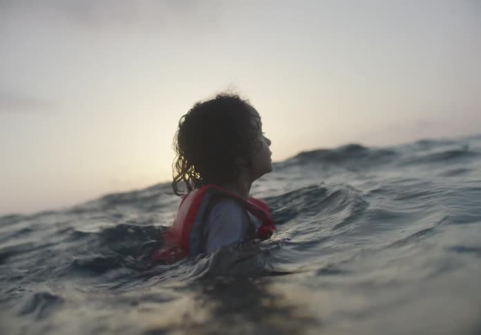The boy is floating and swimming in the water