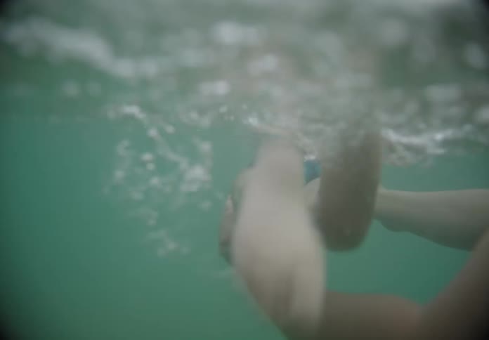 Man teaching a child to swim in the sea