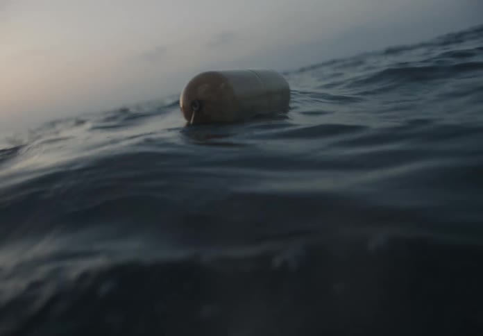 A water float drifts in the middle of the ocean at sundown