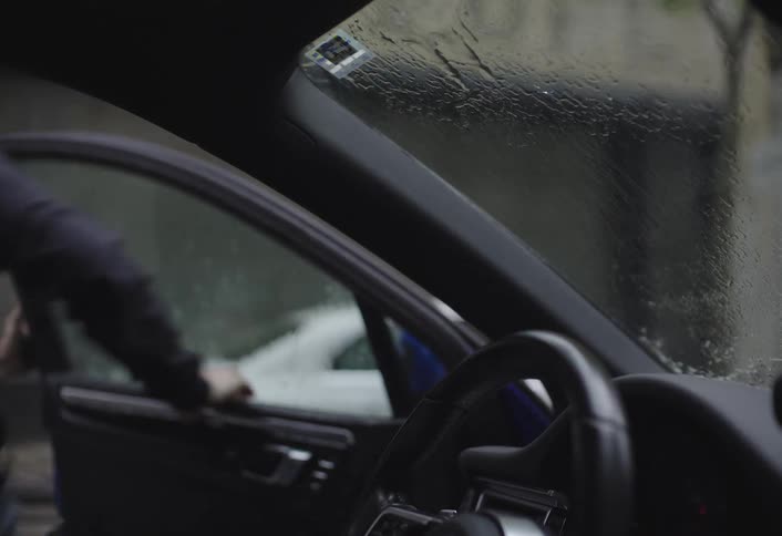 A man gets out of the car and runs in the rain
