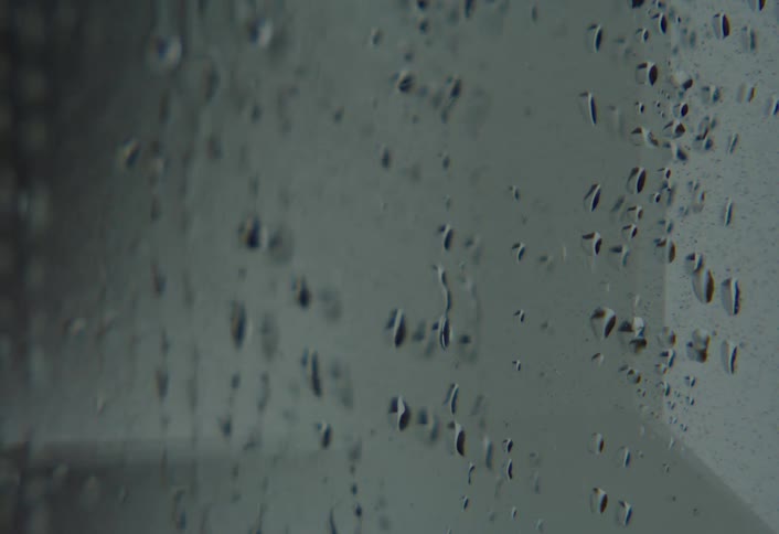 Close up of water droplets dripping down a surface