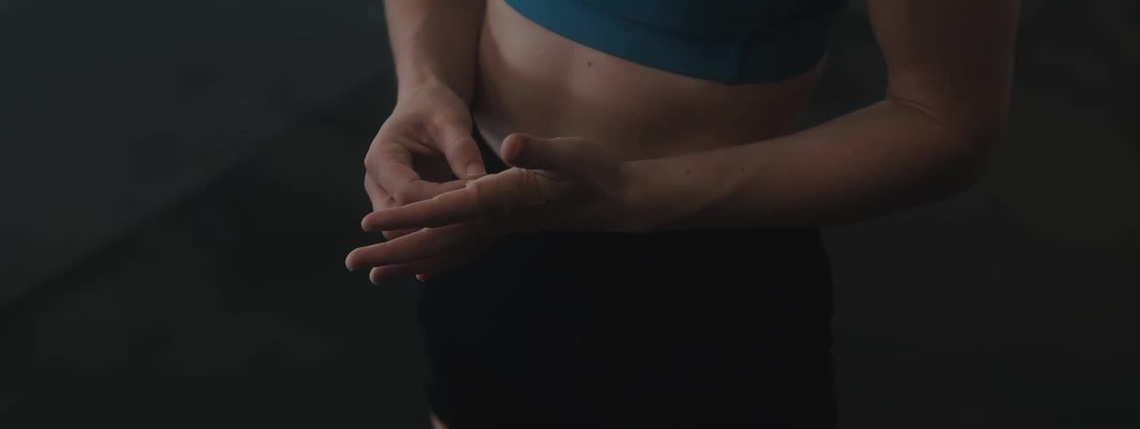 Woman in a gym environment checking her hands
