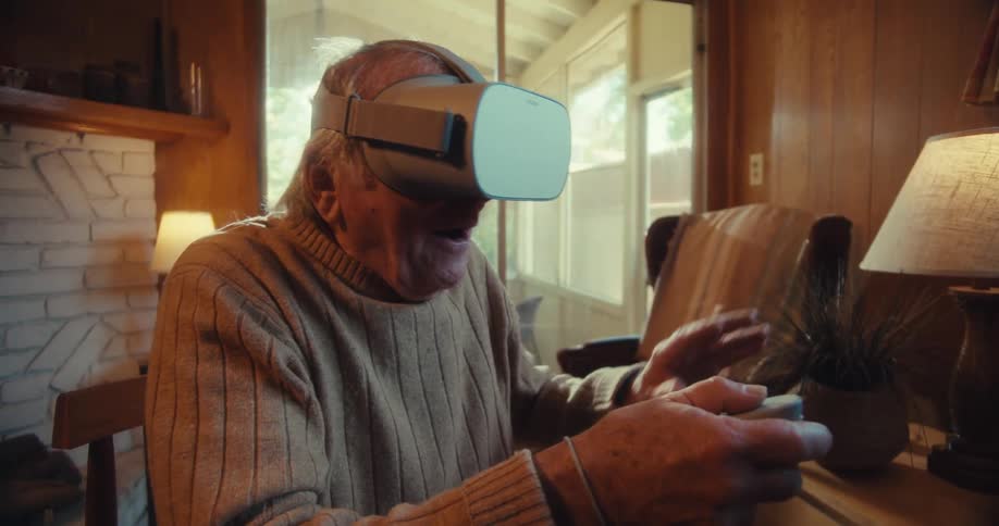 An elderly man wearing a vr headset plays an immersive game in a cozy living room