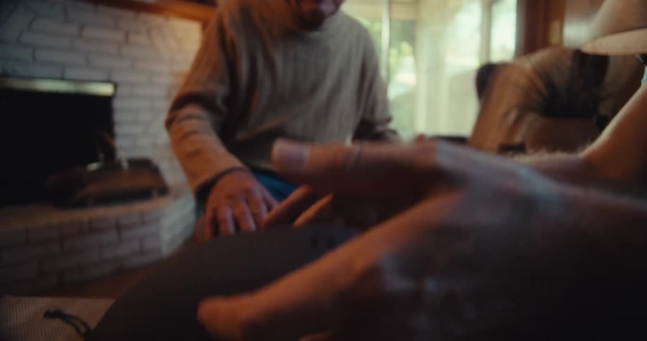 A man opens a case containing a virtual reality headset as an elderly man watches