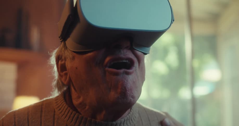 An elderly mine immediate smiles after having his virtual reality headset turned on