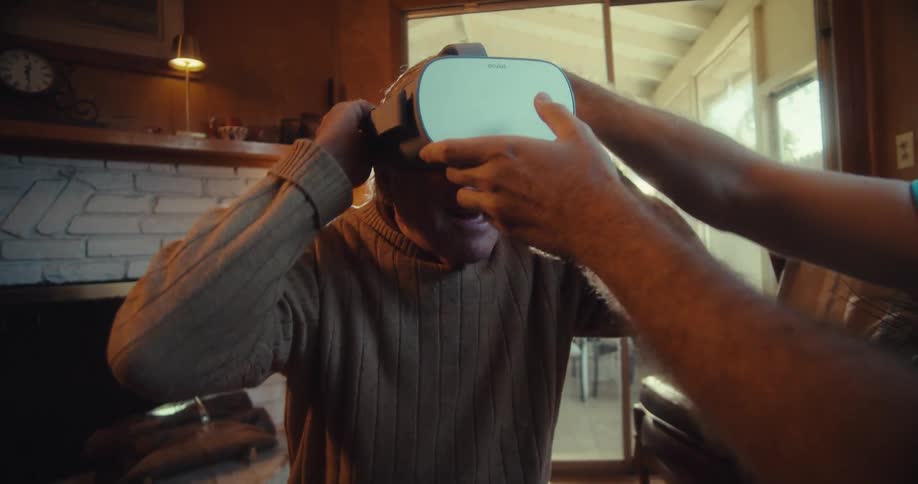 Happy elderly man putting on virtual reality glasses