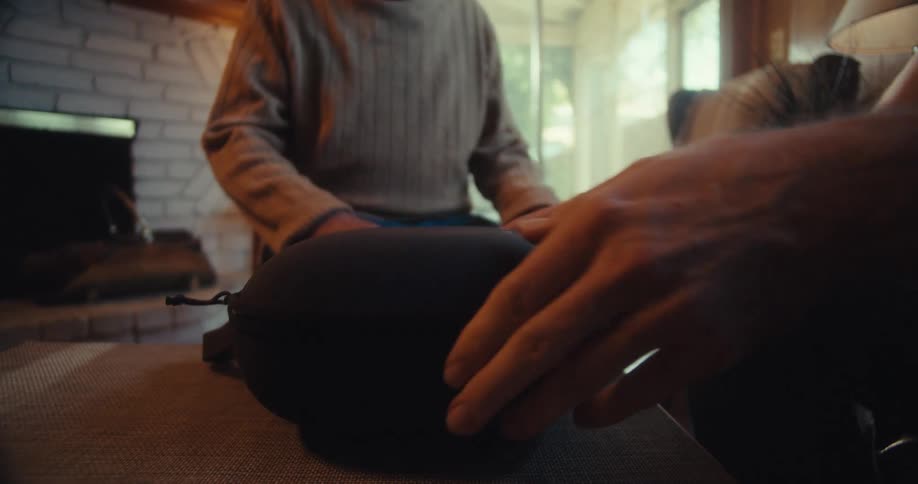 Younger man surprises an older man with a vr headset while they sit in the living room