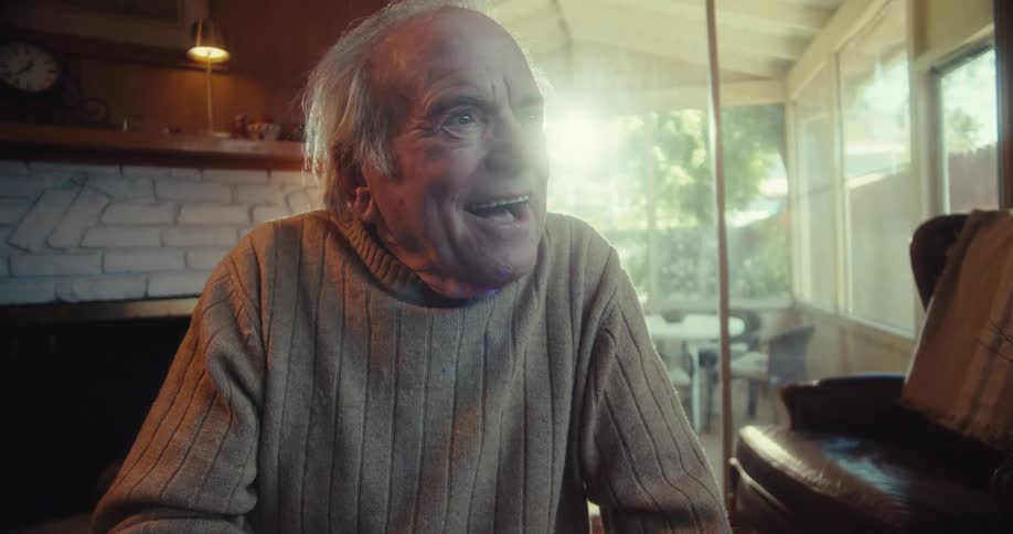 Elderly man enjoys a virtual reality headset then talks to the younger man who removed it from him