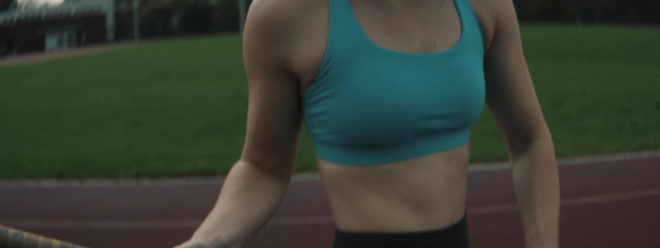 Woman on a running track holding an olympic pole