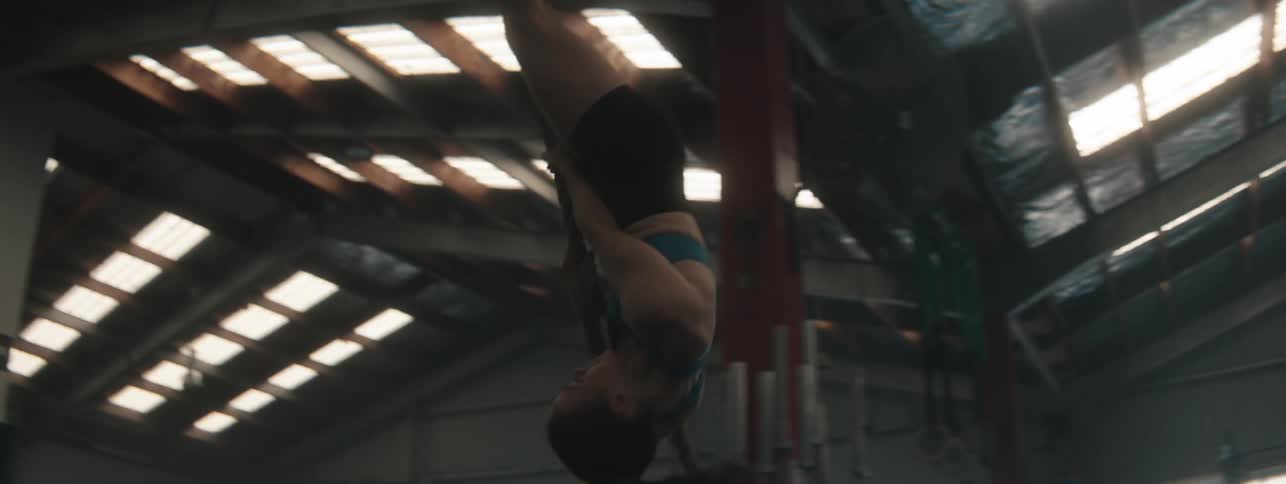 Woman in a gym leaning on a hanging ring