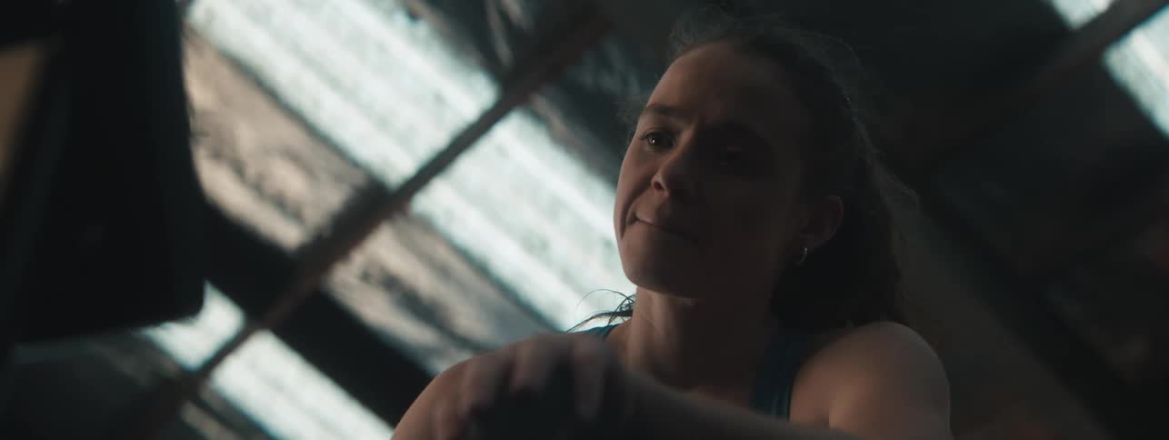 Woman on a gym equipment with a determined expression