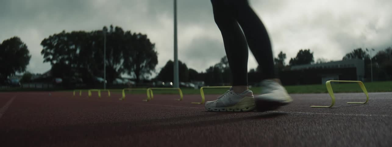 Woman on a running track running and failing at pole vault