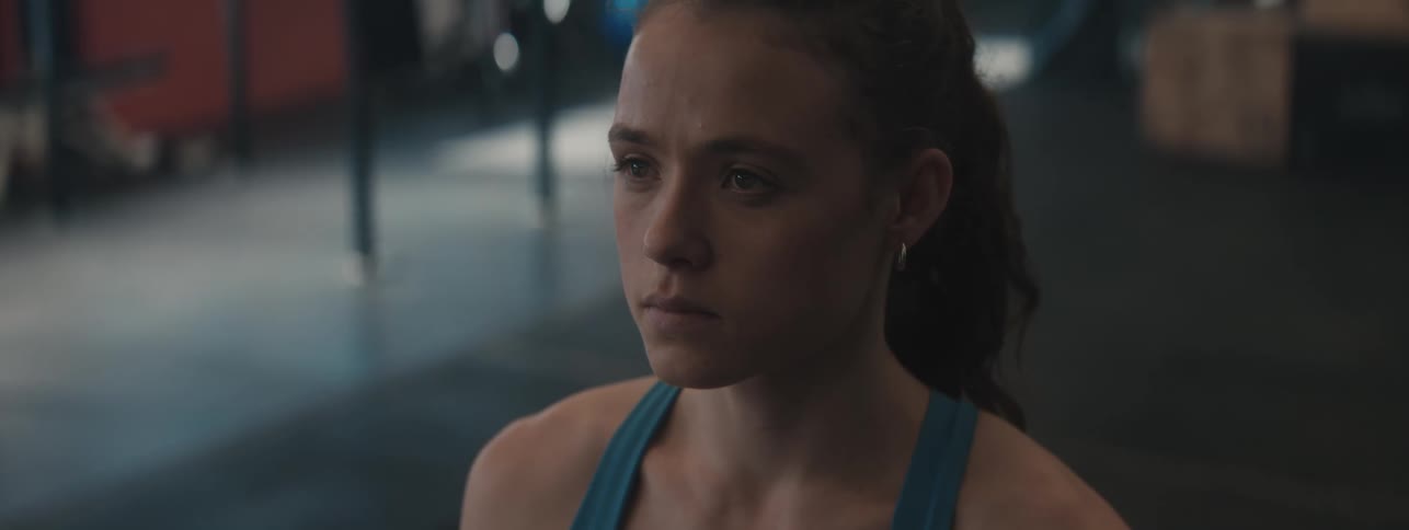 Woman exercising with a determined expression in a gym