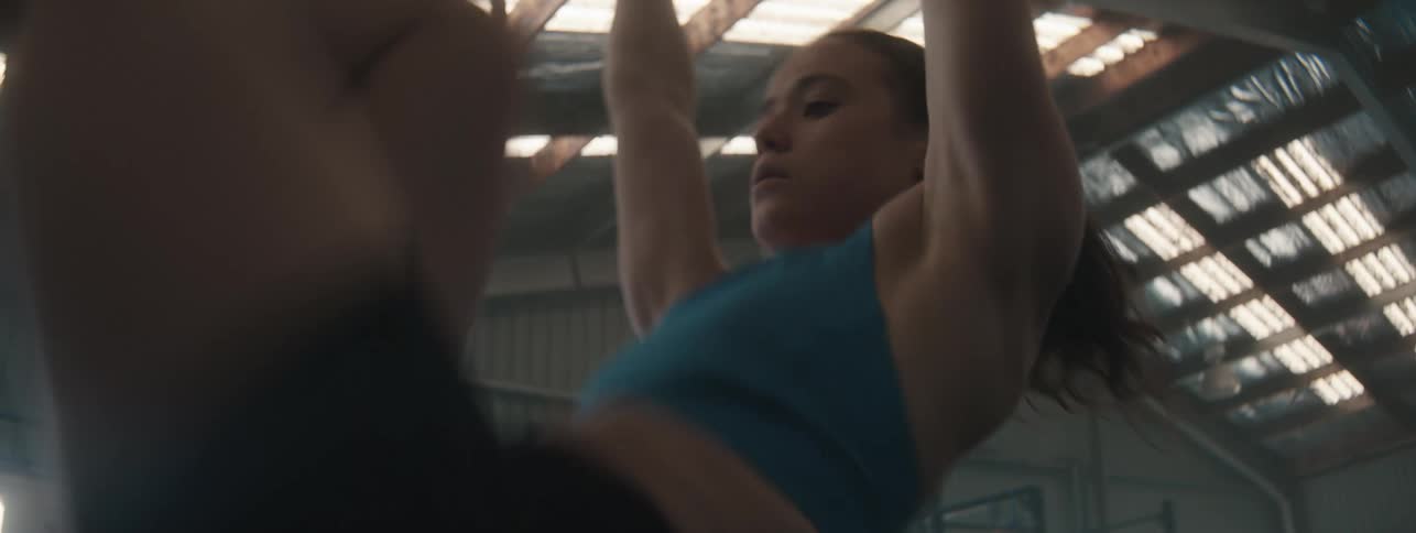 Woman doing abs workout on a free bar in a gym