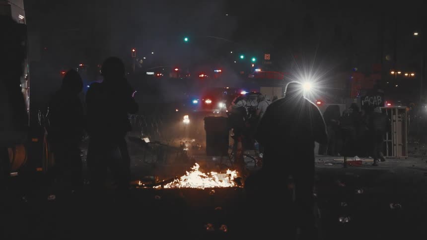 The rioters are burning down the road at night