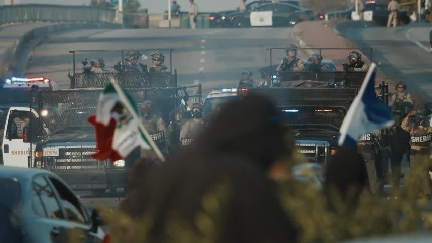 Protesters are blocked by police cars