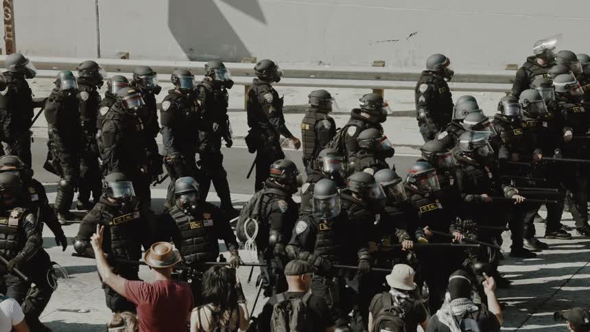 Police troop with weapons advancing through the streets of a city