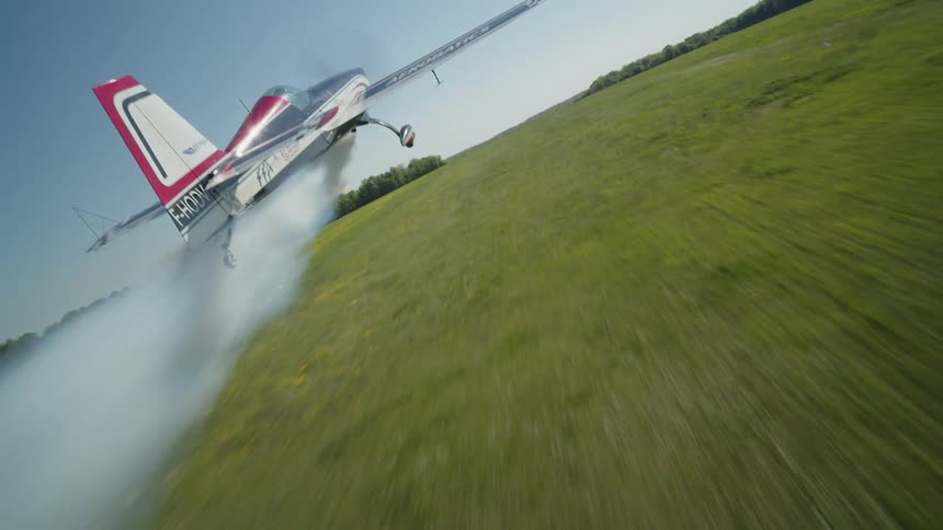 Single engine plane taking off in a large grassy area