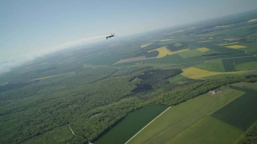 Small singleengine plane maneuvering in the sky and leaving smoke trails
