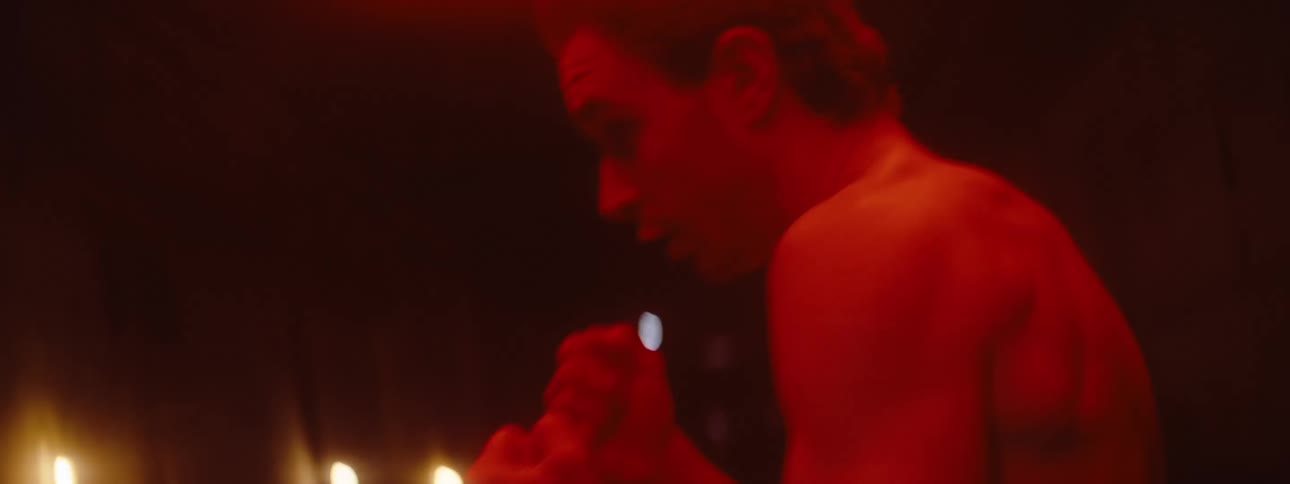 A man is shadowboxing in the dark hall