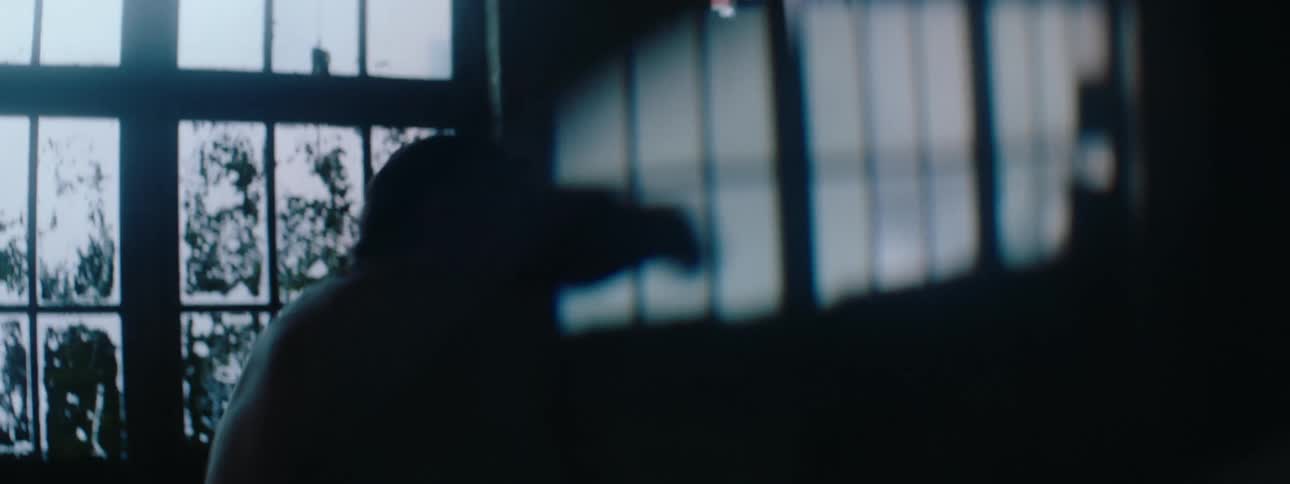 Male boxer shadow boxes in a warehouse during the daytime