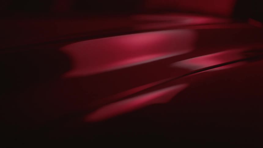 Light and shadow are highlighting a shiny red surface