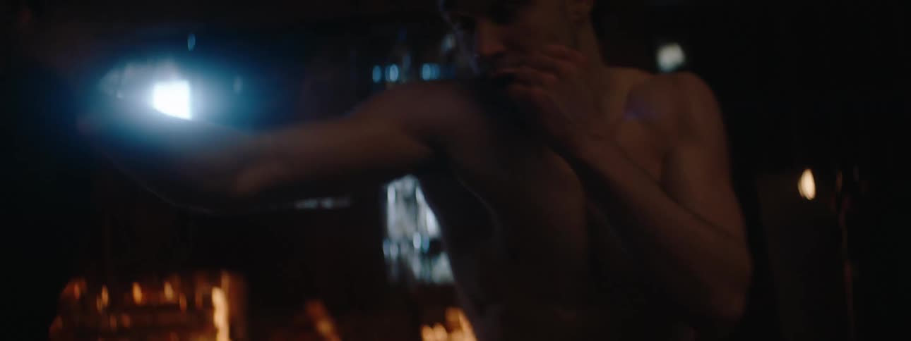 The man is boxing as lights flash on him