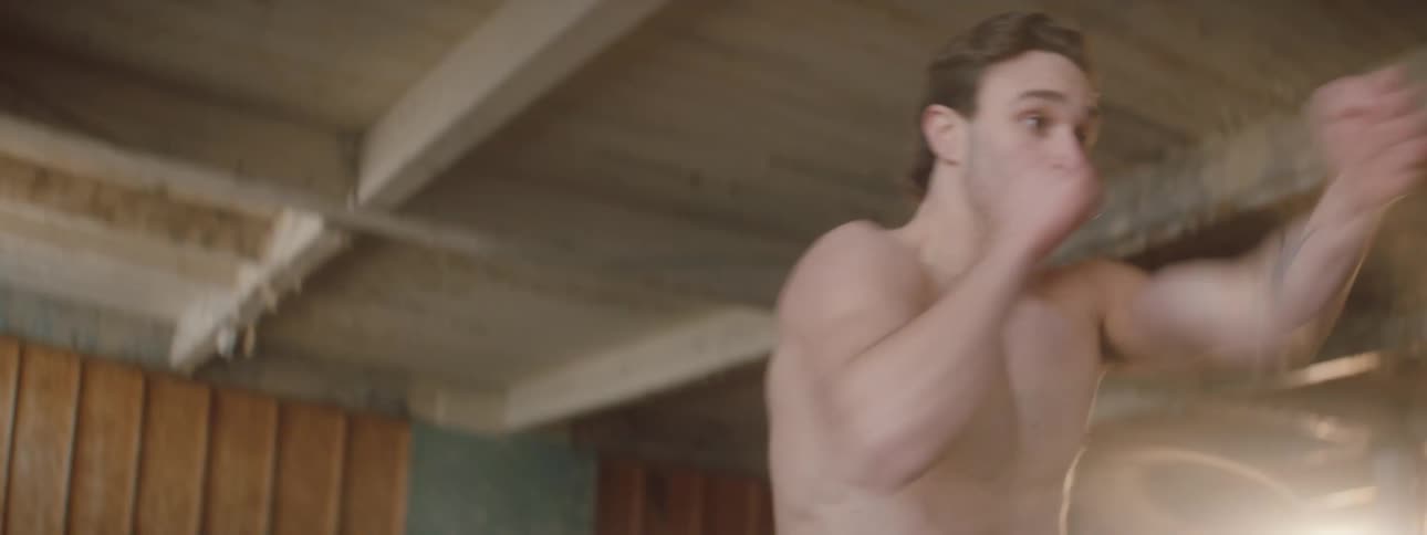 A man is shadowboxing in the large room
