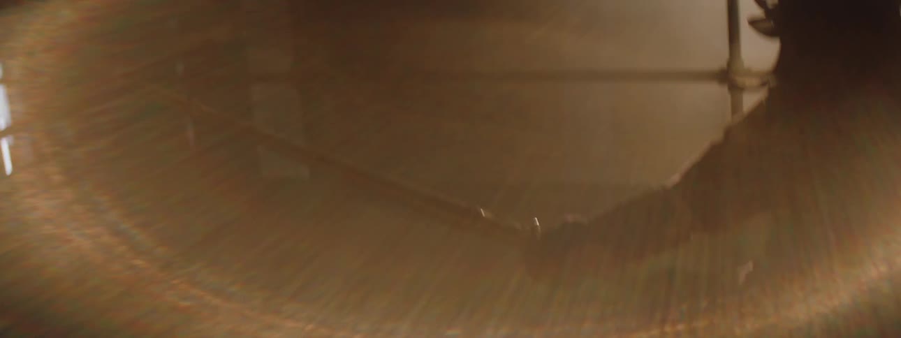 Two people engage in a kendo match inside a ring with bright lights reflecting off the dark stage