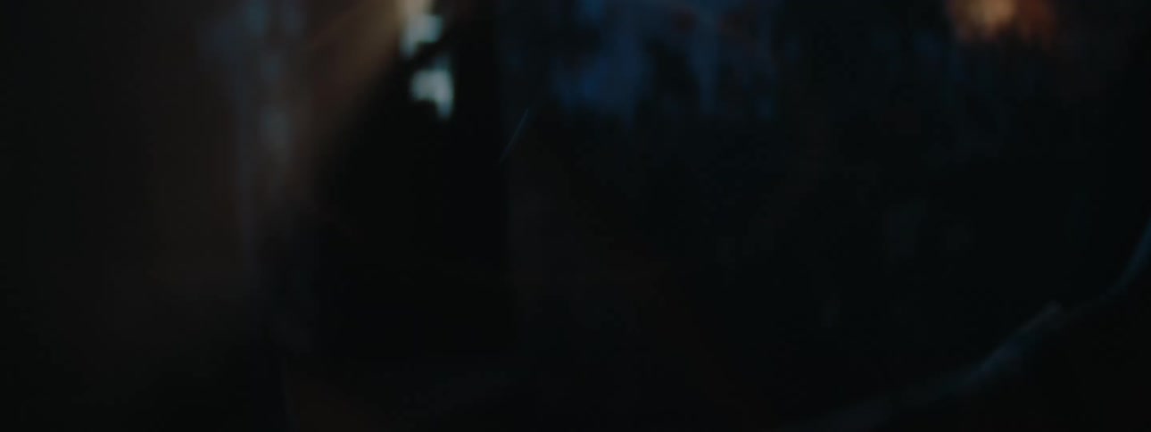 A woman is playing the drums while lights flash on her