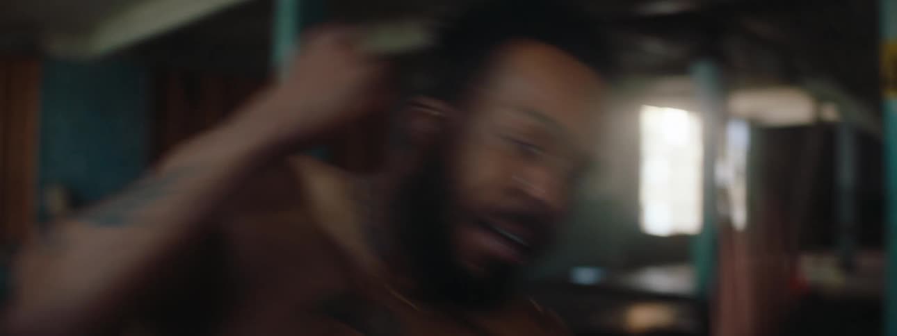 Close up of a young black man practising martial arts in a hall inside an old building