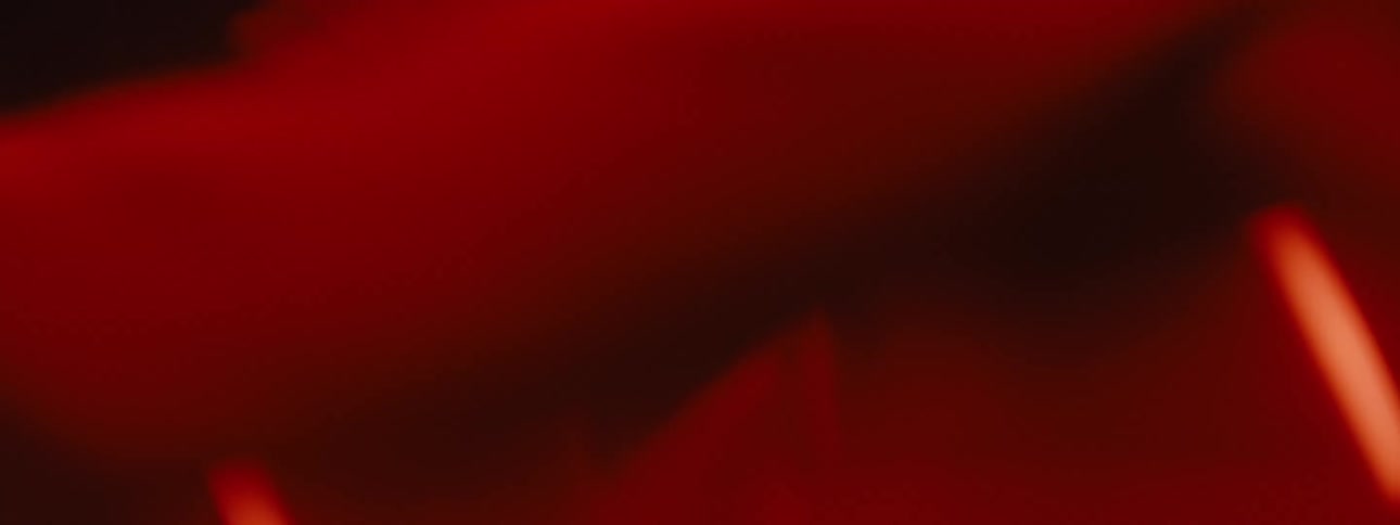 Man in a red light environment without a shirt practicing punches