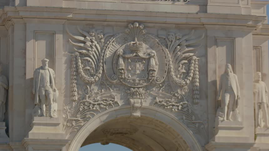 The stone archway has statues in front
