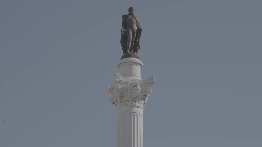 A statue sits perched atop a tall column