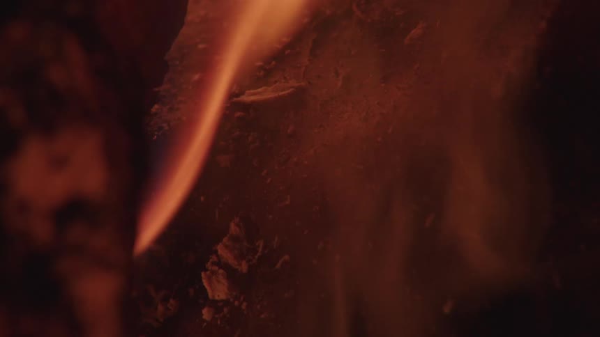 A fire burns with bright yellow flames in the dark of night