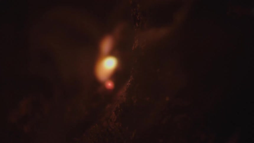 Fire burns slowly as smoke rises from the flames