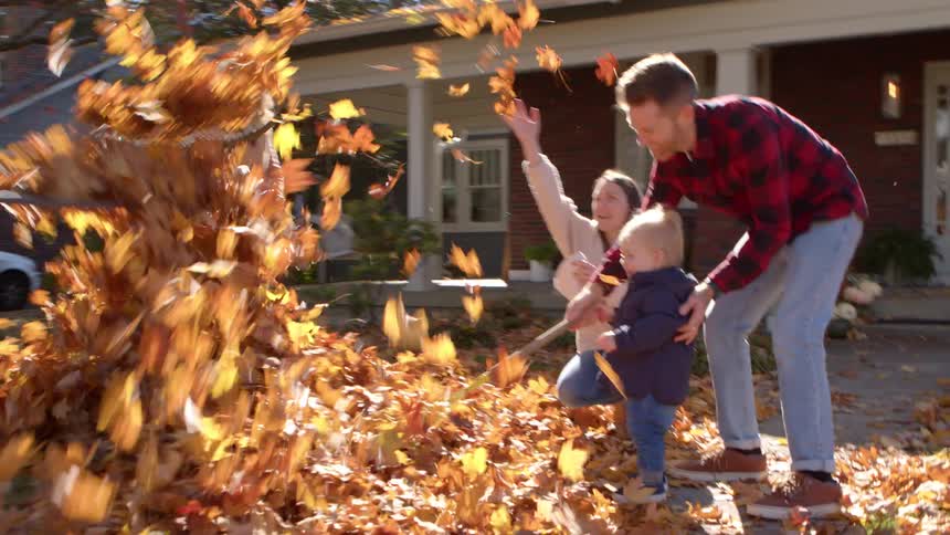 A family throw the leaves in the yard