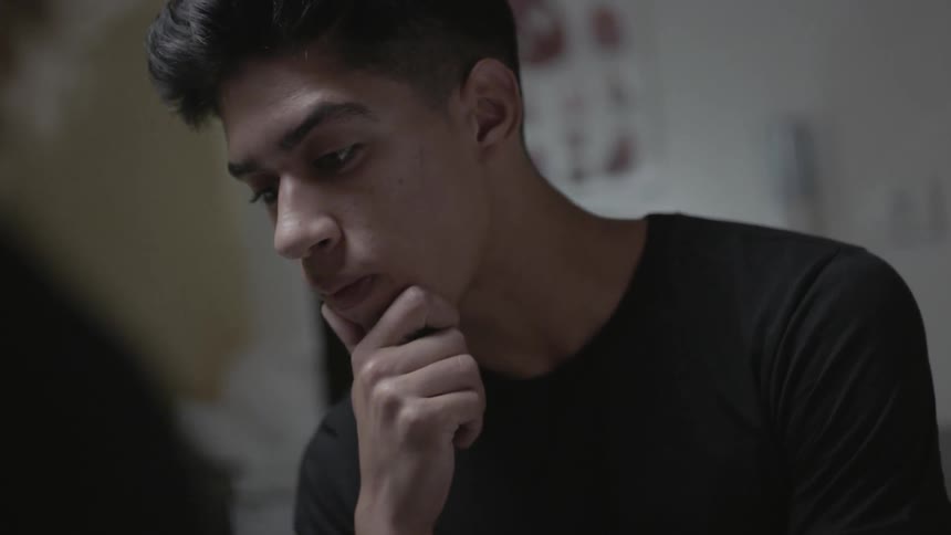 A man is leaning forward on his hand