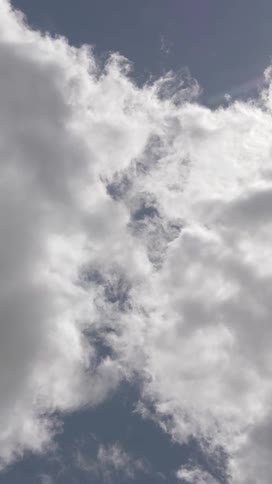 Cumulus clouds move slowlyin a gray tinted sky