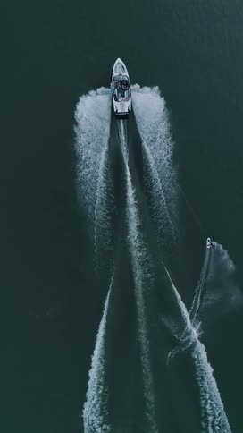Aerial of a boat towing a wake boarder on a lake