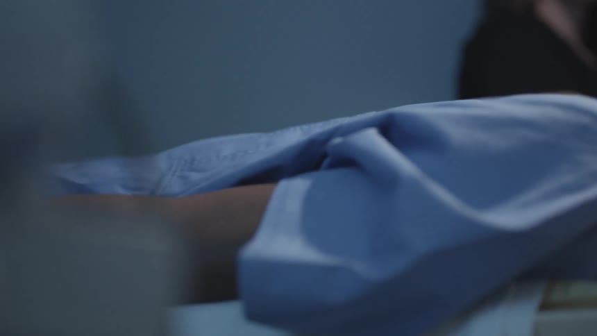 A technician observes as a person goes into an mri machine