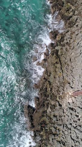 Aerial view of waves crashing against a rocky coastline