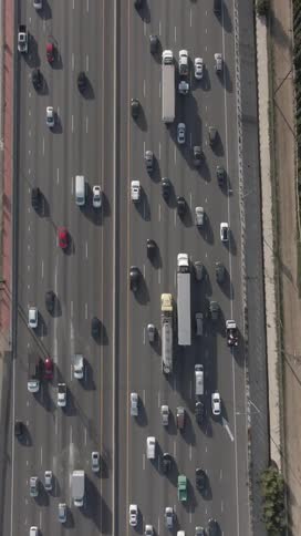 Aerial top view of vehicles driving slowly down a crowded twelve lane highway during the day