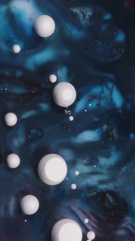 White spheres float in swirling deep blue liquid forming an abstract scene