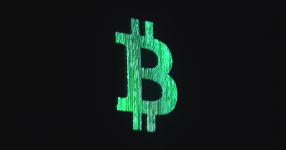 Pixelated screen of futuristic display device plays the moving animation of a flashing crypto currency logo as a symbol for Bitcoin mining via providing computing power to the decentralized BTC network
