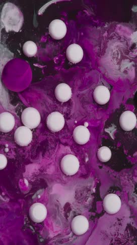 White spheres on a marbled purple liquid background