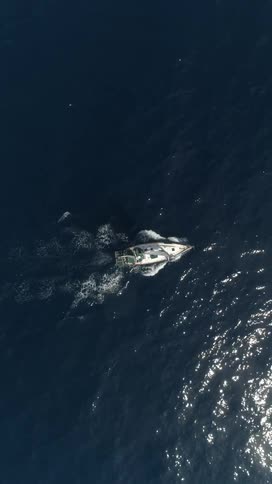 Aerial of a boat moving across the sea surface in daytime