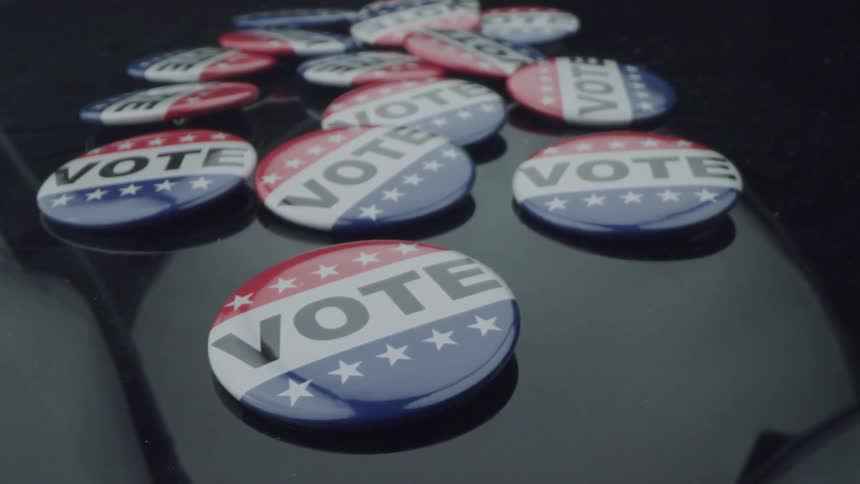 Light is reflecting on a bunch of buttons that say vote