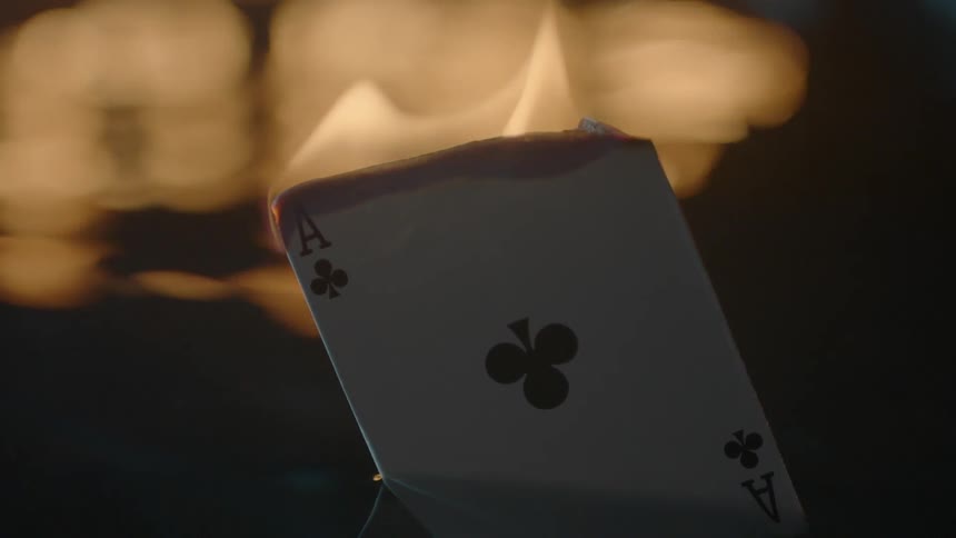 A playing card burns near a body of water